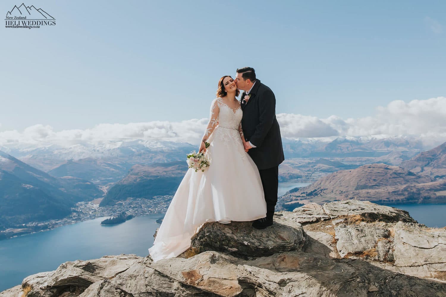 Groom kissing bride in the mountains
