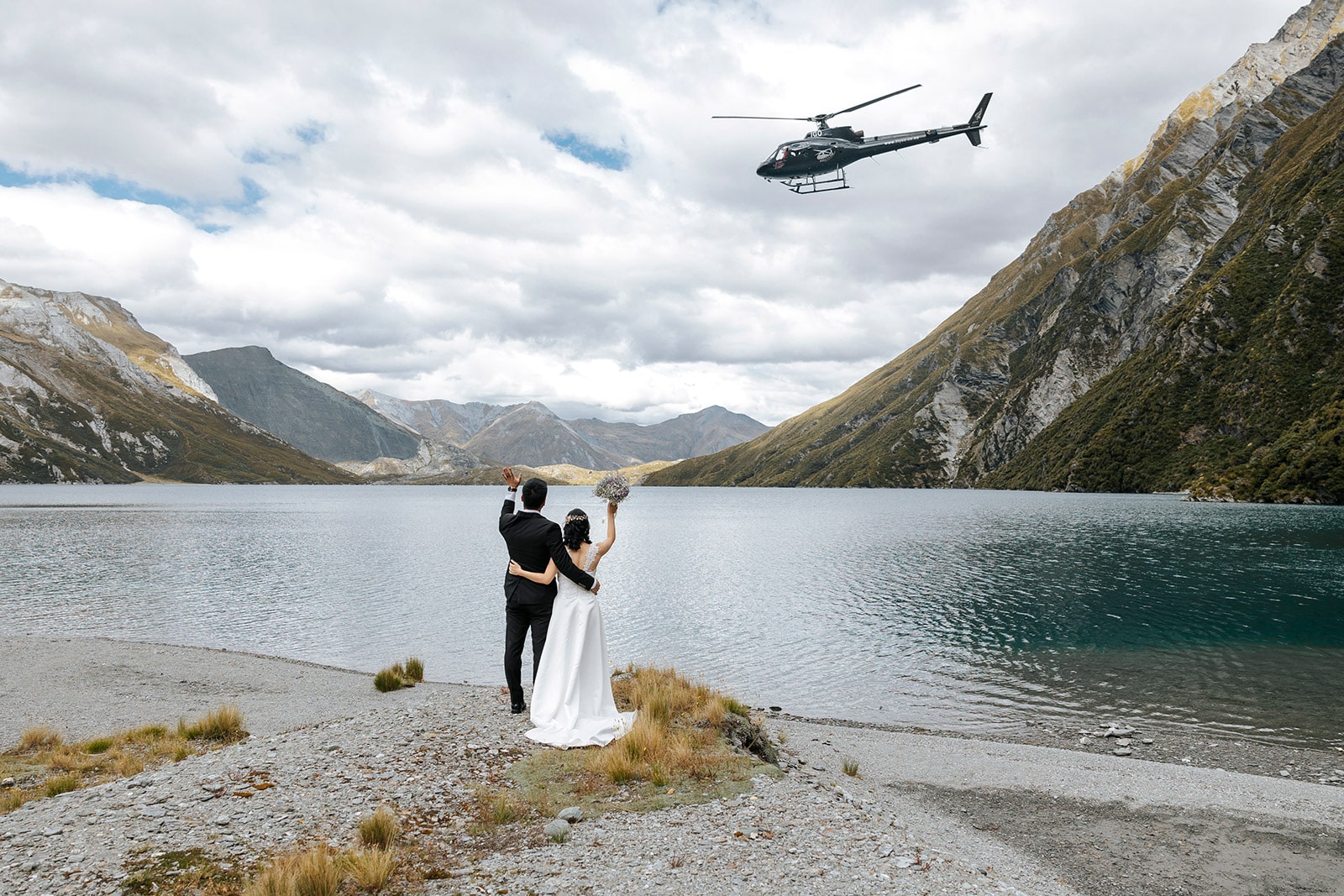 Heli Wedding ceremony at Lochnagar in Queenstown, bride and groom with helicopter in the background