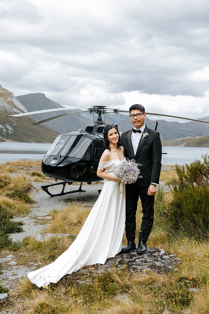 Heli Wedding ceremony at Lochnagar in Queenstown, bride and groom with helicopter in the background