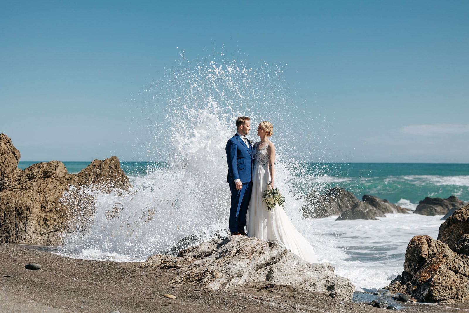 Milford Ultimate Wedding package in Queenstown, Bride and groom on the beach on the west coast of New Zealand